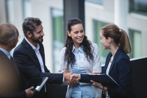 Business professionals collaborating near office staircase, illustrating leadership and support as trusted Chiefs of Staff